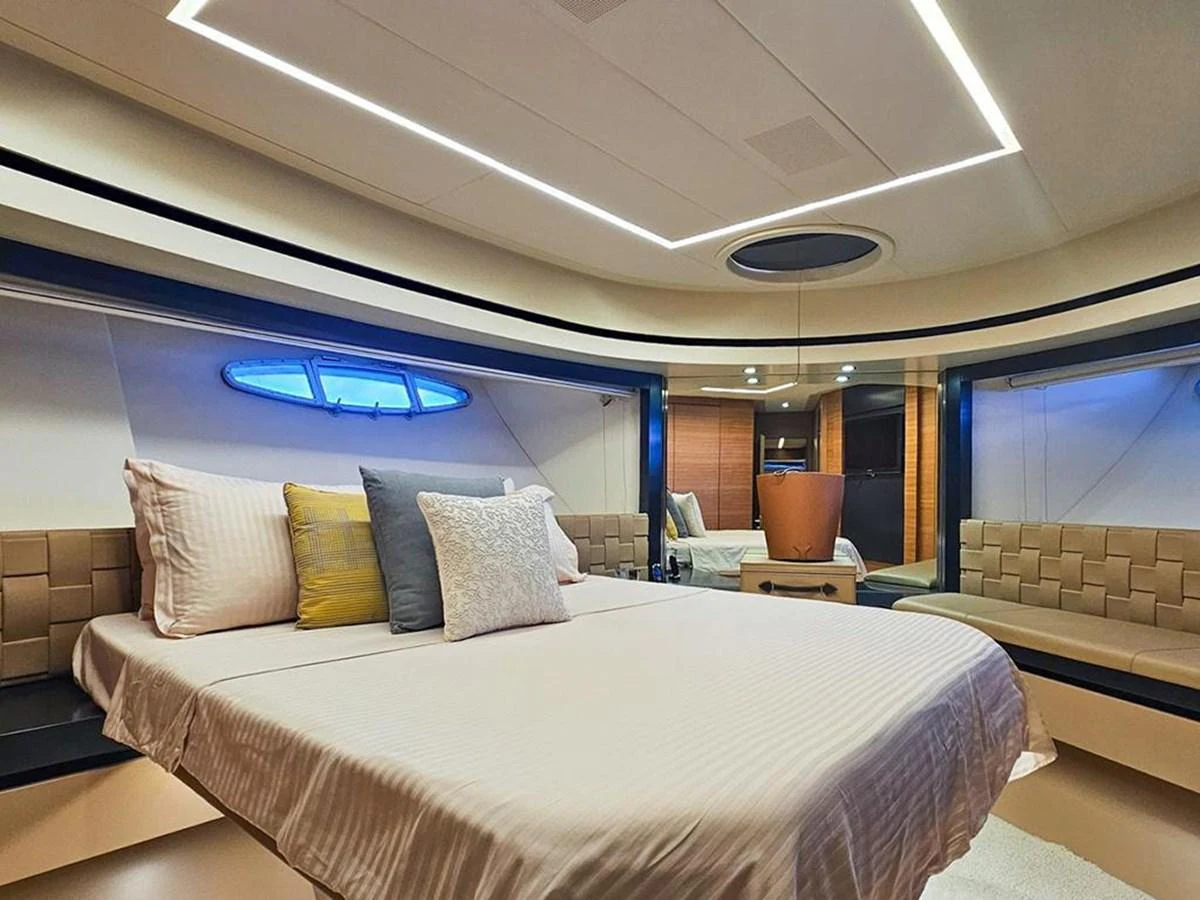 The master stateroom features a luxurious bed with elegant lighting and modern design elements. aboard HONEY BADGER Yacht for Sale