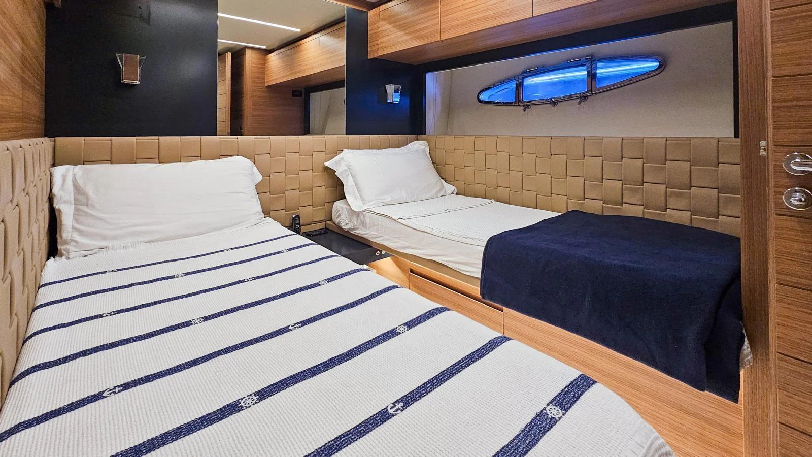 The guest cabin features two single beds with elegant bedding and a modern, cozy design. aboard HONEY BADGER Yacht for Sale