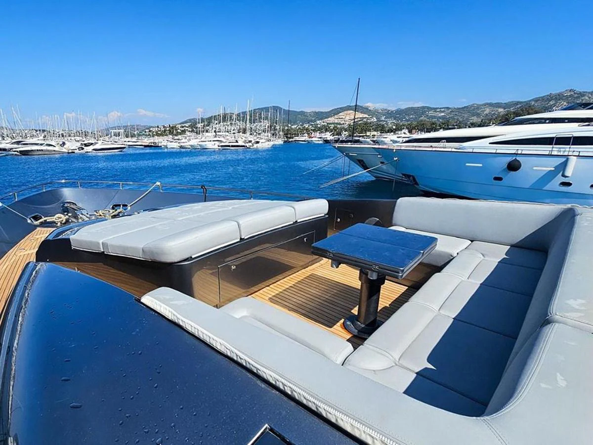 The yacht's aft deck features a spacious seating area with a sleek table, perfect for enjoying the scenic views. aboard HONEY BADGER Yacht for Sale
