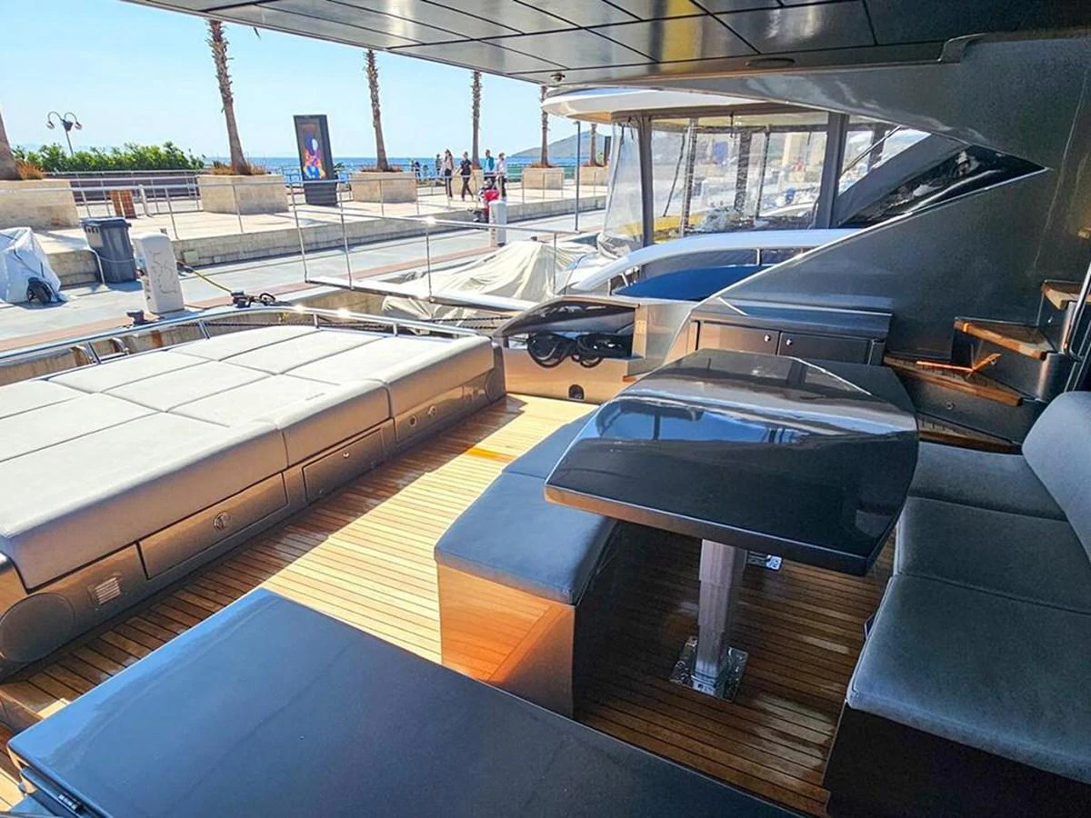 The aft deck features a sleek dining area with a modern table and comfortable seating, perfect for alfresco dining. aboard HONEY BADGER Yacht for Sale