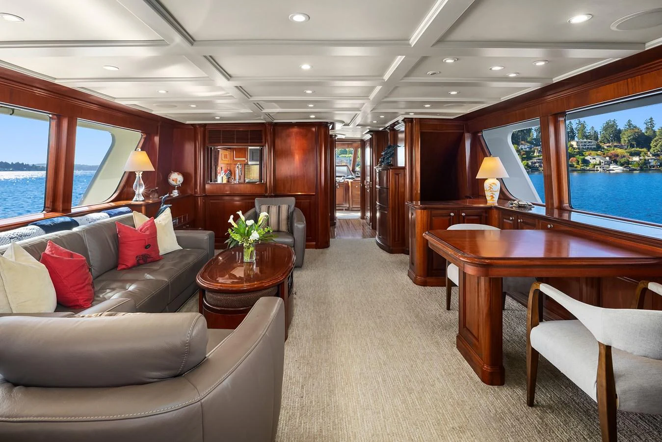 The yacht's salon exudes elegance with its rich wood finishes and comfortable seating, offering stunning views through large windows. aboard MI AMERE Yacht for Sale