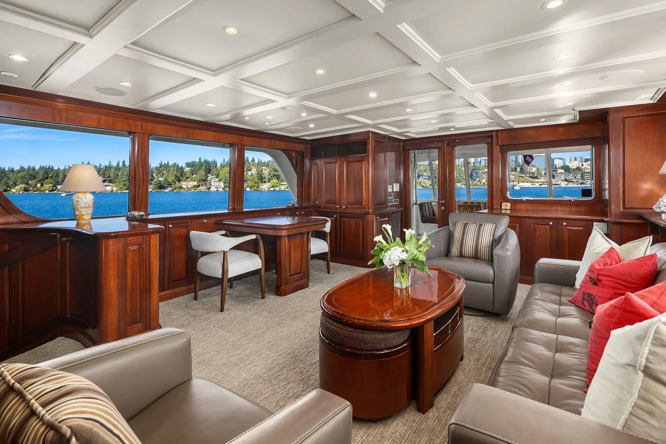 The salon features elegant wood paneling, plush seating, and large windows offering stunning views. aboard MI AMERE Yacht for Sale