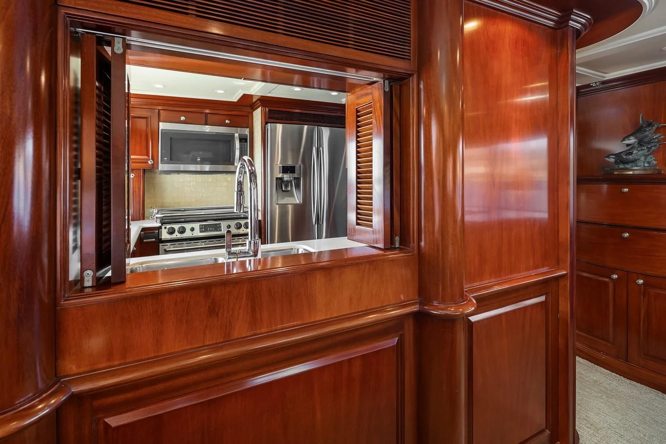 The yacht's galley features rich wooden cabinetry and modern stainless steel appliances. aboard MI AMERE Yacht for Sale