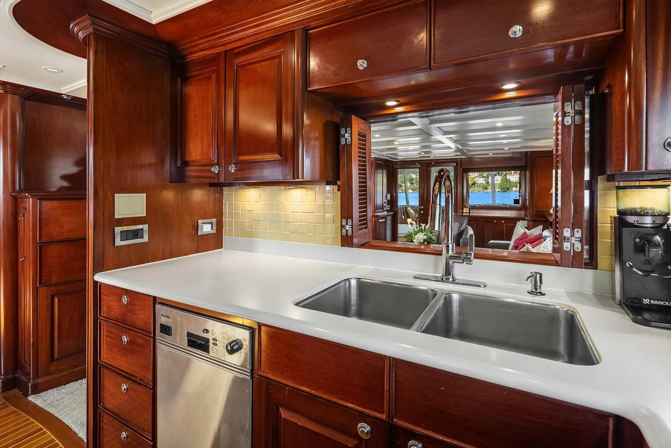 The yacht's galley features rich wooden cabinetry, modern appliances, and a sleek countertop. aboard MI AMERE Yacht for Sale