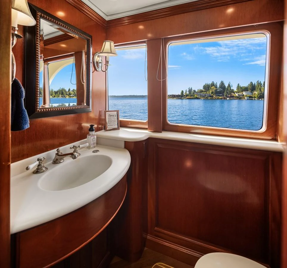A luxurious yacht bathroom with a large window offering a scenic view of the water. aboard MI AMERE Yacht for Sale