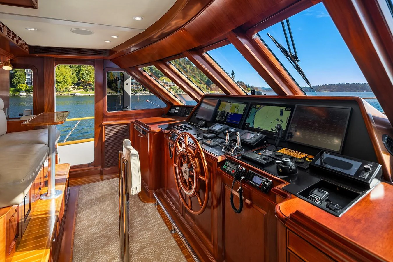 The helm station features luxurious wood finishes and state-of-the-art navigation equipment with panoramic views. aboard MI AMERE Yacht for Sale