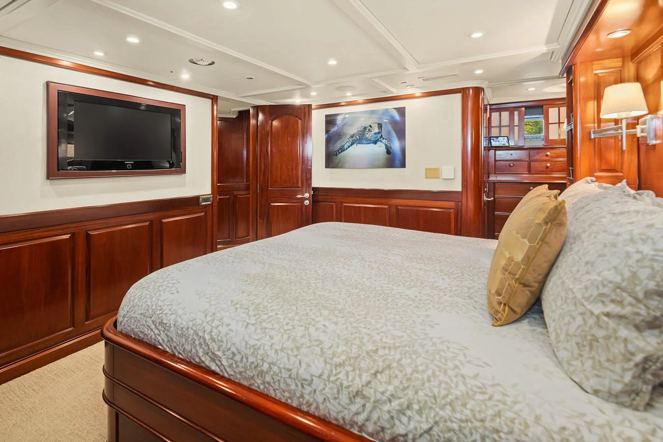 The stateroom features elegant wood paneling, a large bed, and modern amenities for a comfortable stay. aboard MI AMERE Yacht for Sale