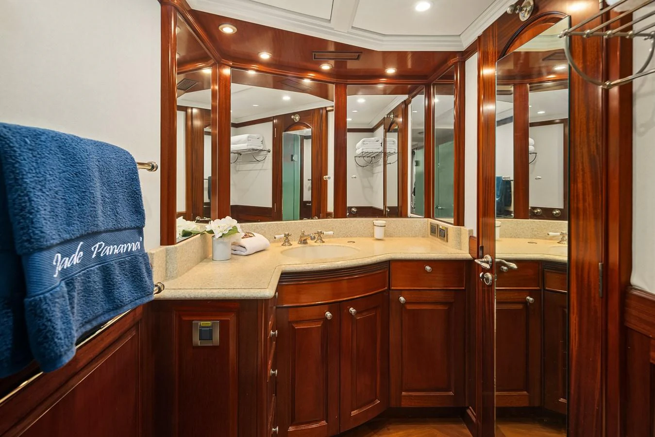 The bathroom features elegant wood cabinetry and a spacious countertop with multiple mirrors. aboard MI AMERE Yacht for Sale
