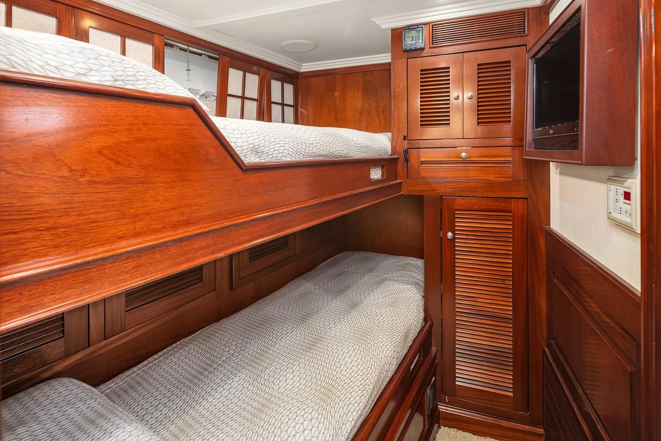 The cozy cabin features wooden bunk beds with elegant paneling and soft bedding. aboard MI AMERE Yacht for Sale