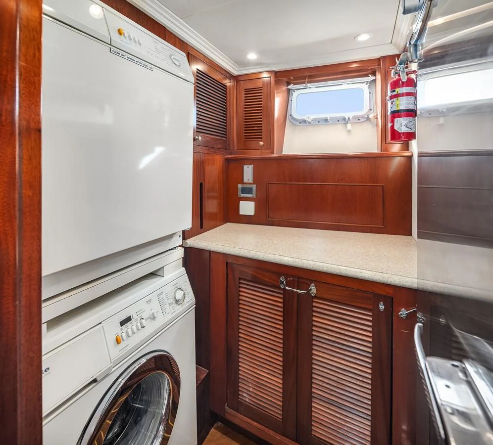 The yacht's laundry room features modern appliances and elegant wooden cabinetry. aboard MI AMERE Yacht for Sale