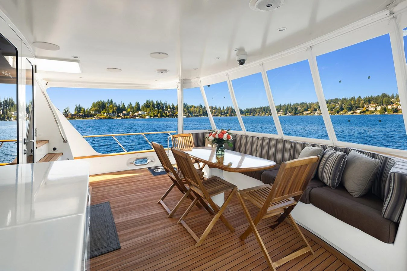 The aft deck offers a spacious and inviting area with comfortable seating and a dining table, perfect for enjoying scenic views. aboard MI AMERE Yacht for Sale