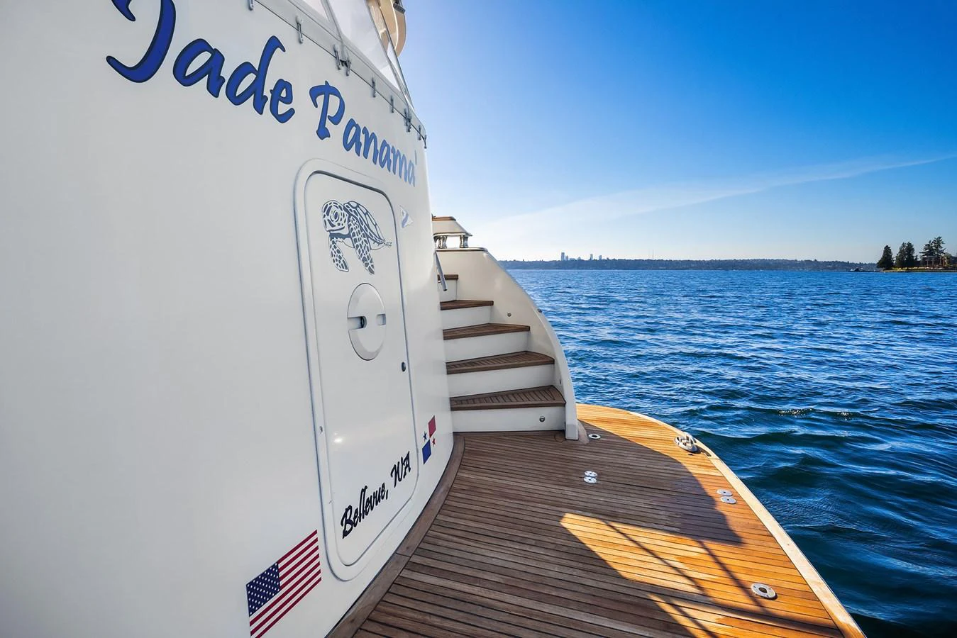 The aft deck offers a serene view of the water with wooden flooring and steps leading up. aboard MI AMERE Yacht for Sale