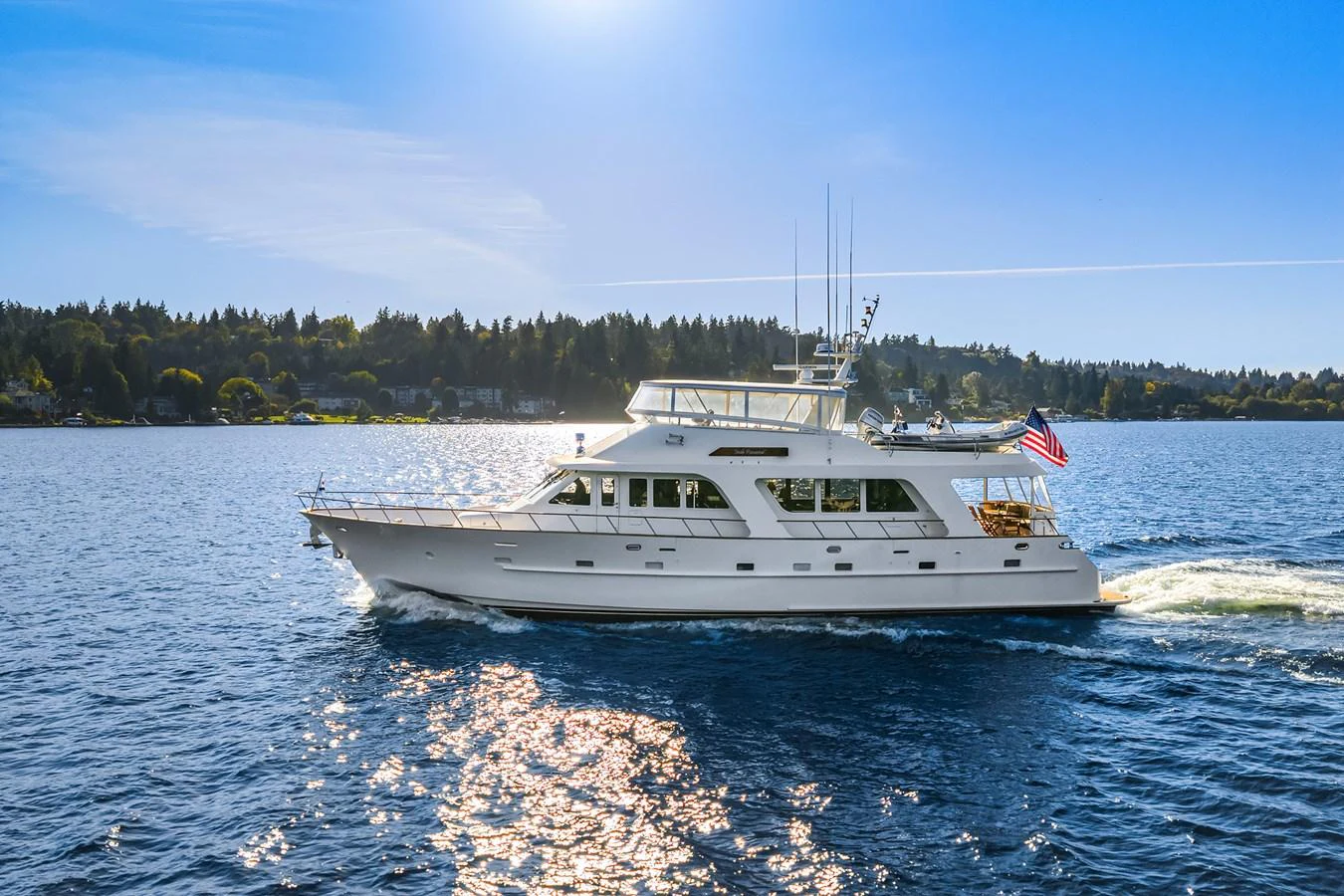 A classic yacht cruises gracefully on a serene body of water under a clear blue sky. aboard MI AMERE Yacht for Sale