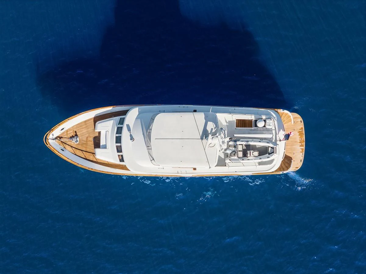 A stunning aerial view of a sleek yacht cruising through deep blue waters. aboard MI AMERE Yacht for Sale