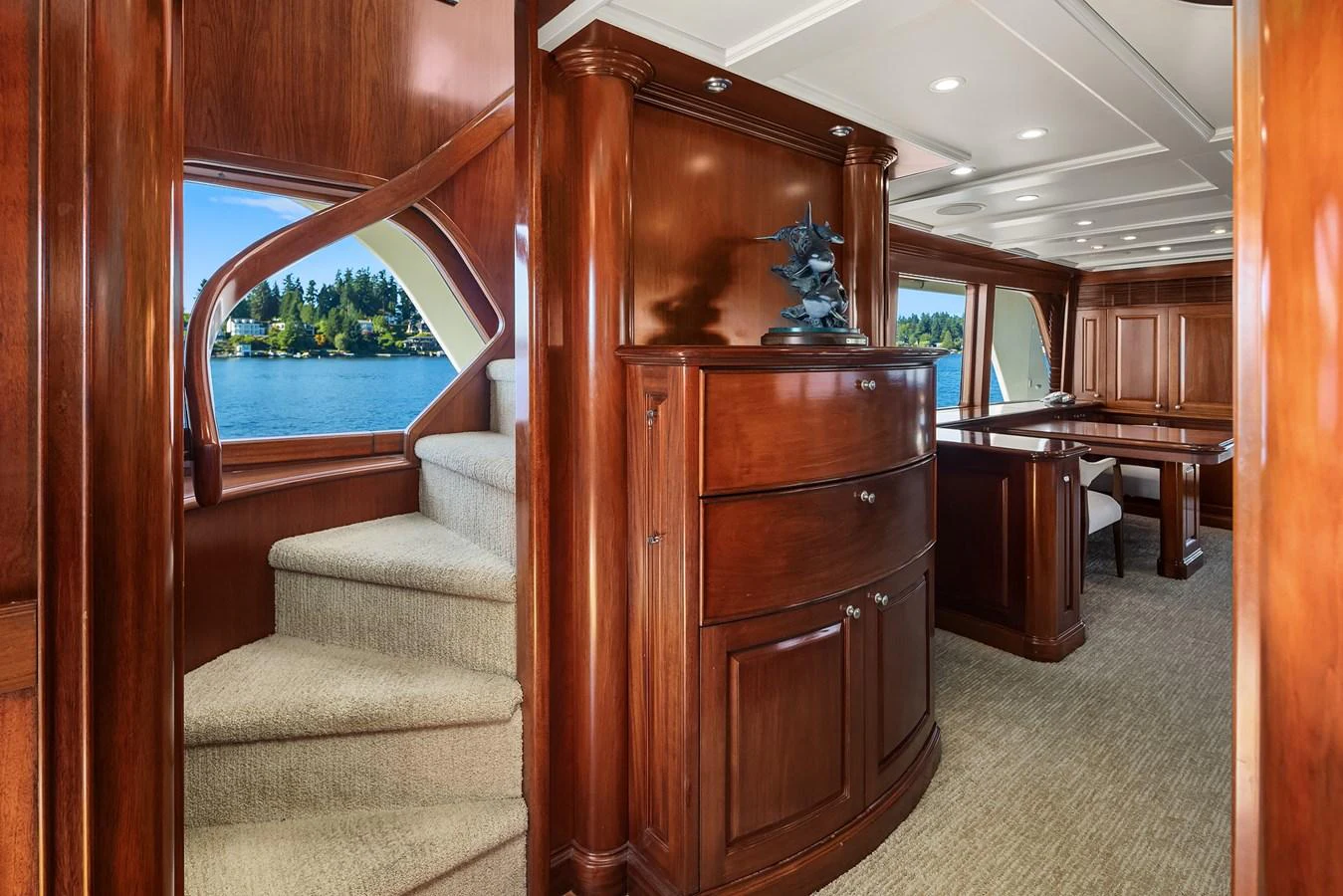 The yacht's interior features elegant wooden cabinetry and a staircase leading to the upper deck. aboard MI AMERE Yacht for Sale