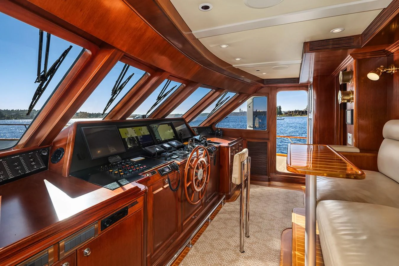 The helm station features rich wood finishes and state-of-the-art navigation equipment with panoramic views. aboard MI AMERE Yacht for Sale
