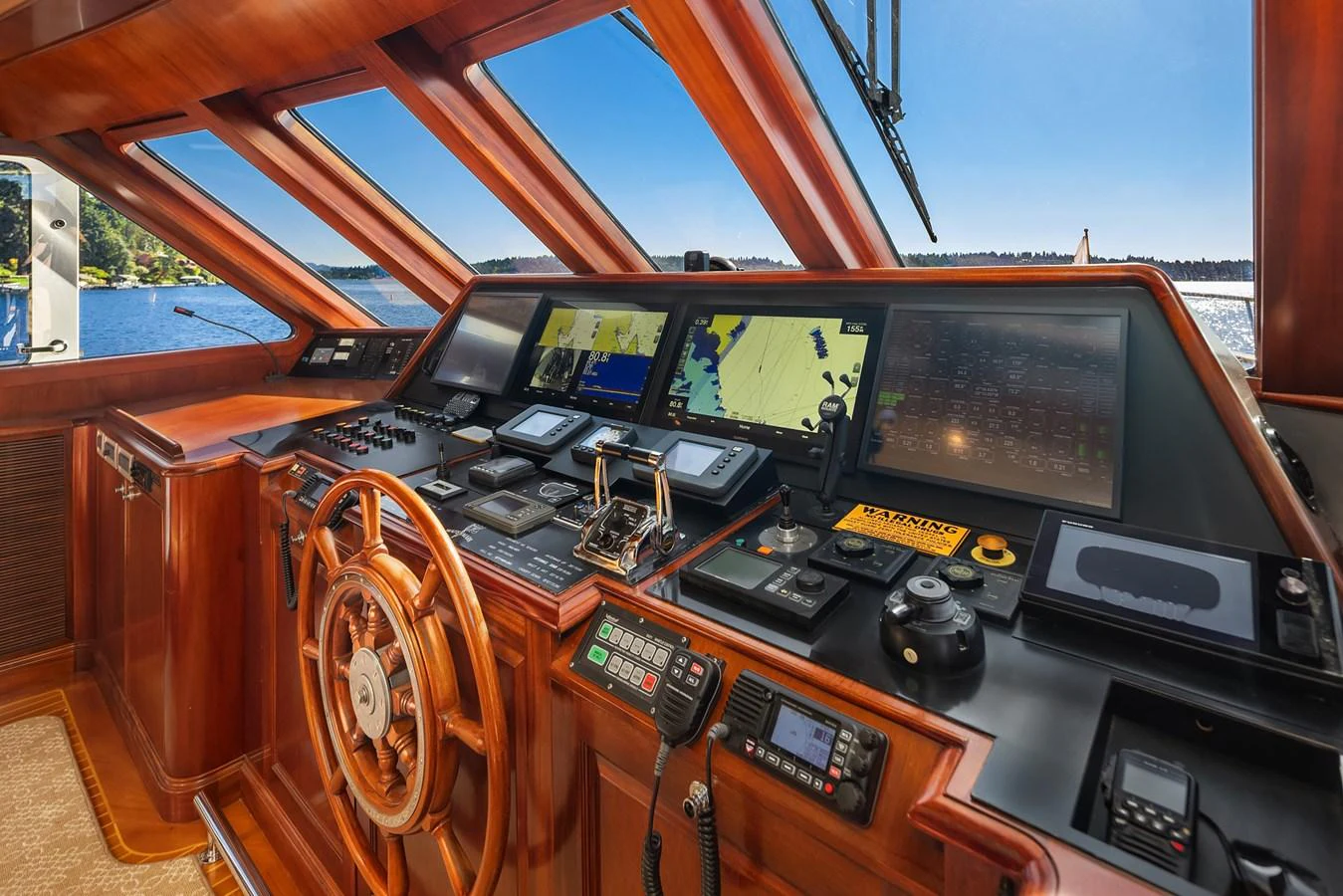 The helm station features advanced navigation equipment and luxurious wood finishes, offering a commanding view of the water. aboard MI AMERE Yacht for Sale