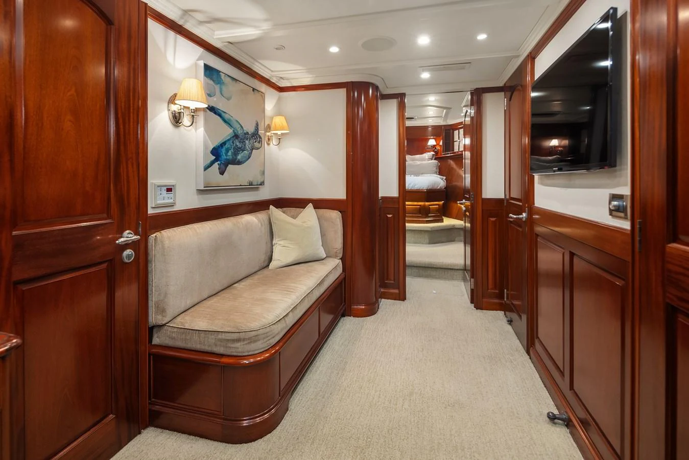 The yacht's interior features a cozy seating area with elegant wooden paneling and soft lighting. aboard MI AMERE Yacht for Sale