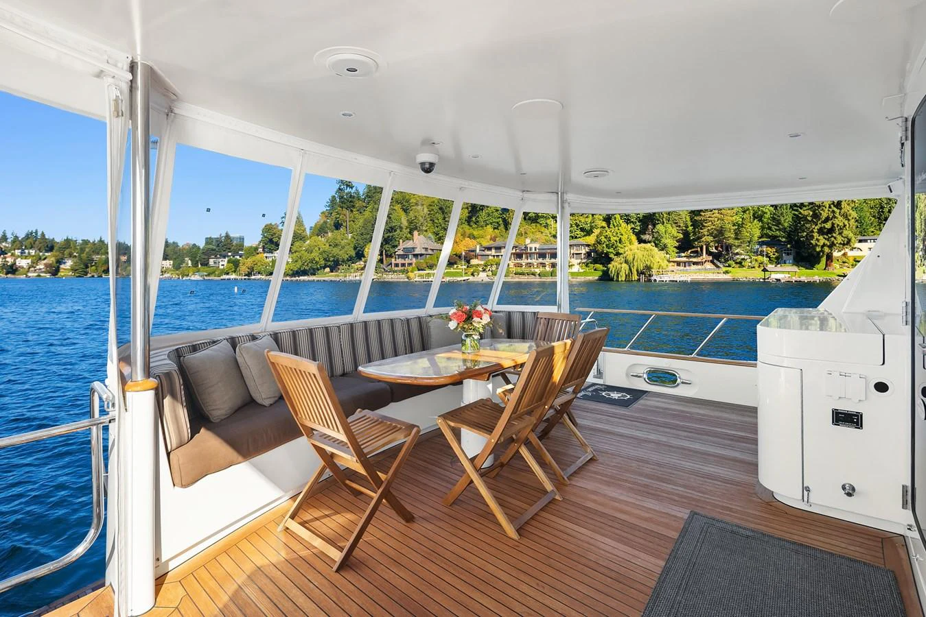 The aft deck offers a cozy dining area with a stunning view of the water and surrounding landscape. aboard MI AMERE Yacht for Sale