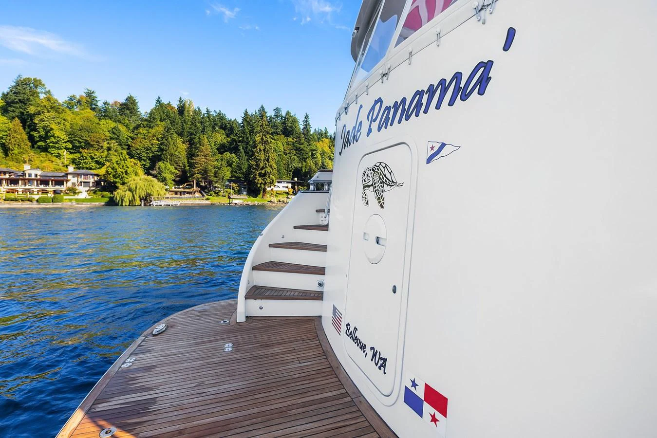 The image showcases the stern detail of a yacht with visible stairs and a wooden deck. aboard MI AMERE Yacht for Sale