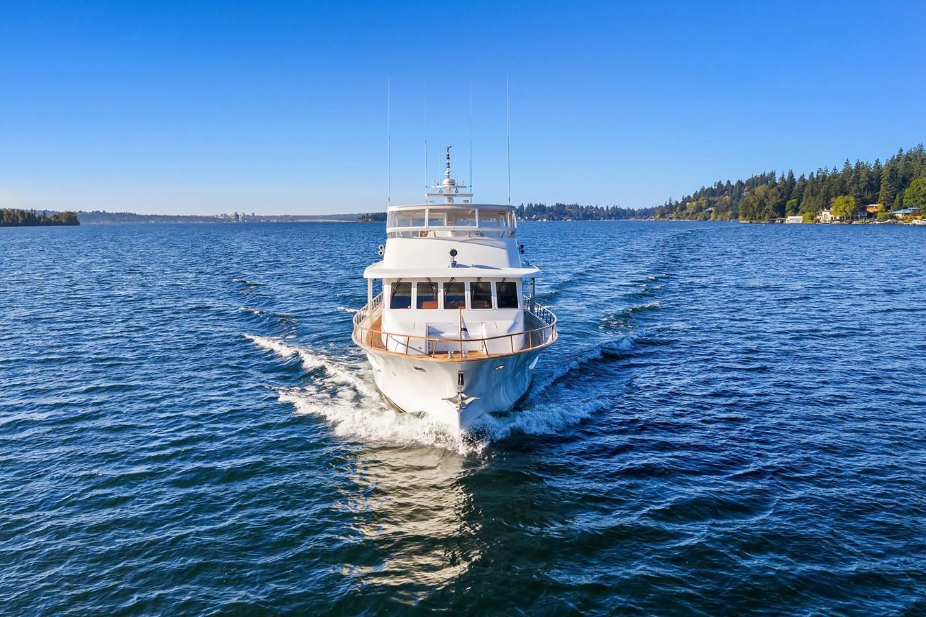 A luxurious yacht cruises through calm, blue waters under a clear sky. aboard MI AMERE Yacht for Sale