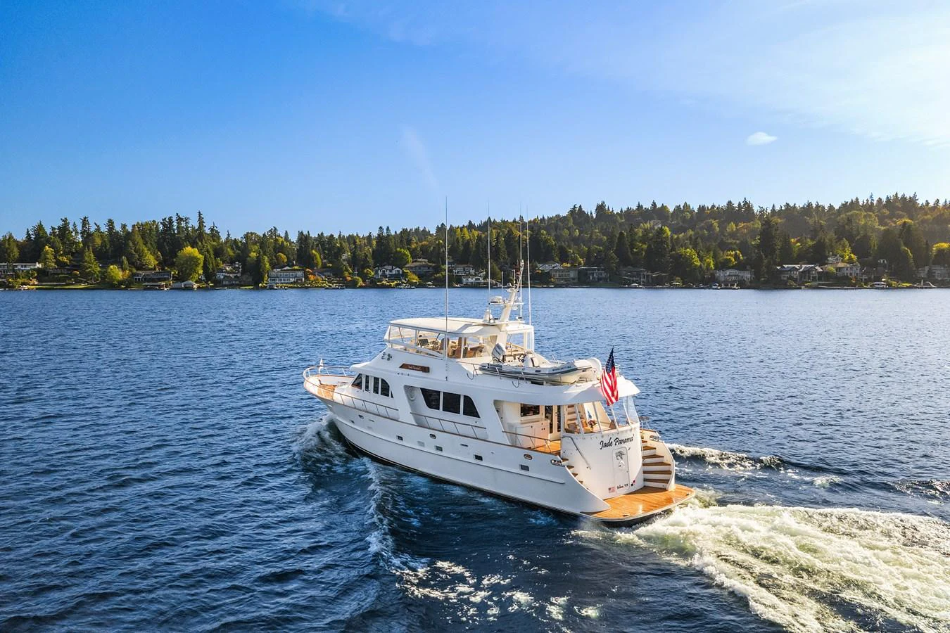 A luxurious yacht cruises through calm waters on a sunny day, showcasing its elegant design and spacious decks. aboard MI AMERE Yacht for Sale