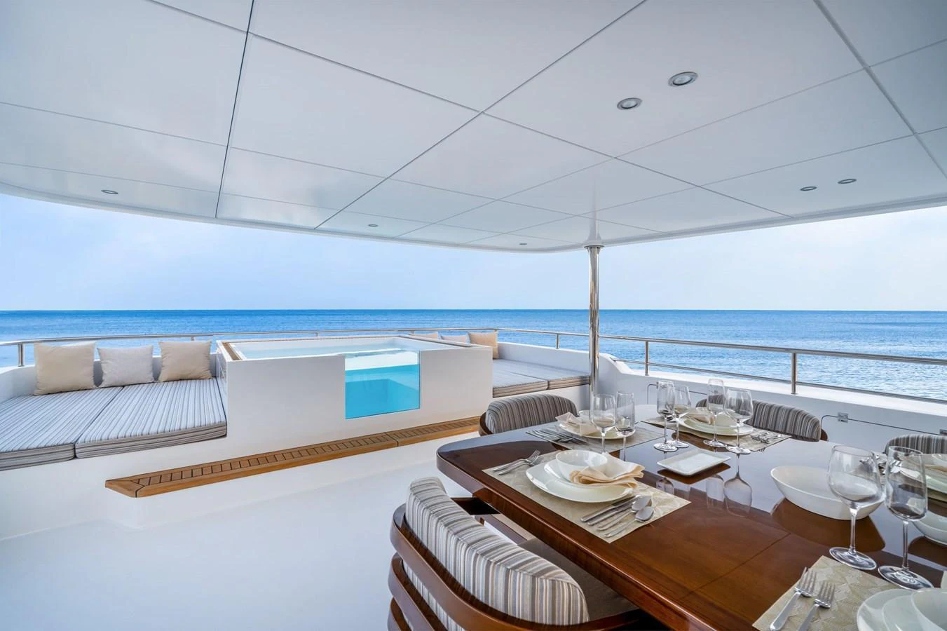 The aft deck features a luxurious dining area with a stunning ocean view and a comfortable lounging space. aboard E SERIES 125 HARGRAVE SUPERYACHTS Yacht for Sale