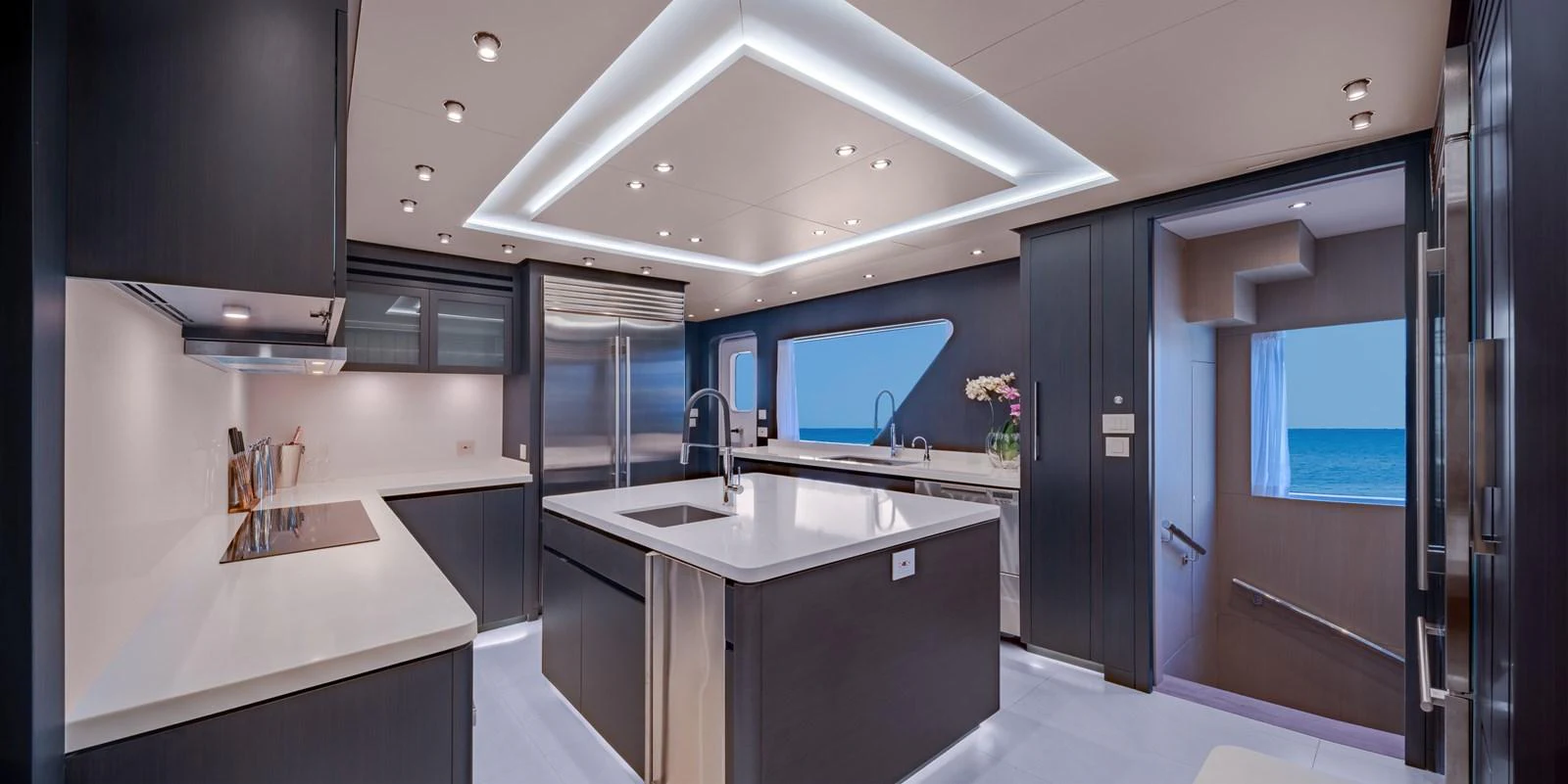 The modern galley features sleek cabinetry, high-end appliances, and ample counter space with a view of the sea. aboard E SERIES 125 HARGRAVE SUPERYACHTS Yacht for Sale