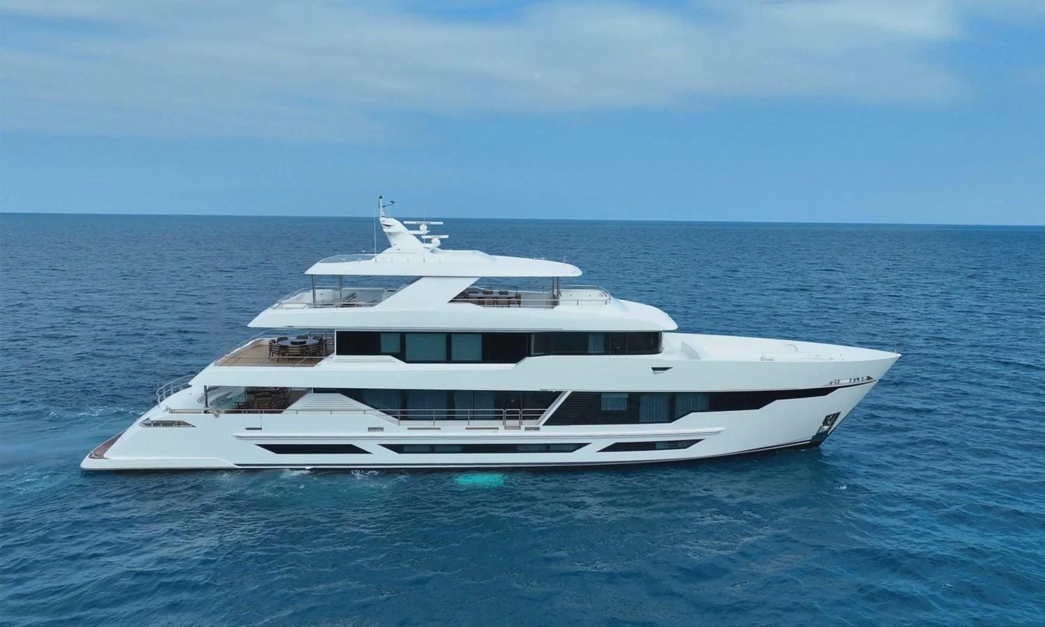 A sleek, modern yacht glides gracefully on the open sea under a clear sky. aboard E SERIES 125 HARGRAVE SUPERYACHTS Yacht for Sale