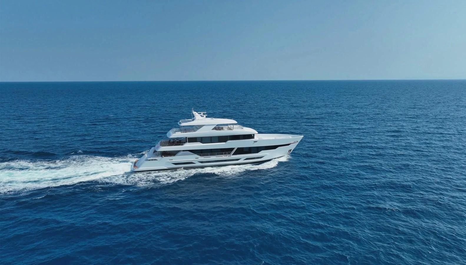 A sleek and modern yacht cruising on the open sea under a clear blue sky. aboard E SERIES 125 HARGRAVE SUPERYACHTS Yacht for Sale