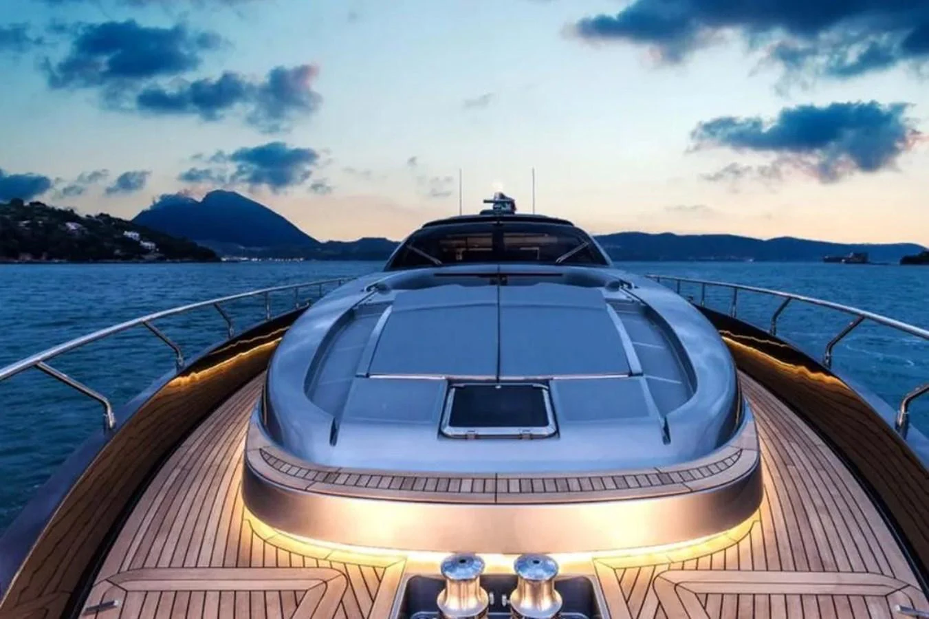 The yacht's sleek foredeck is beautifully illuminated against a serene twilight backdrop. aboard ANTIOXIDANT Yacht for Sale