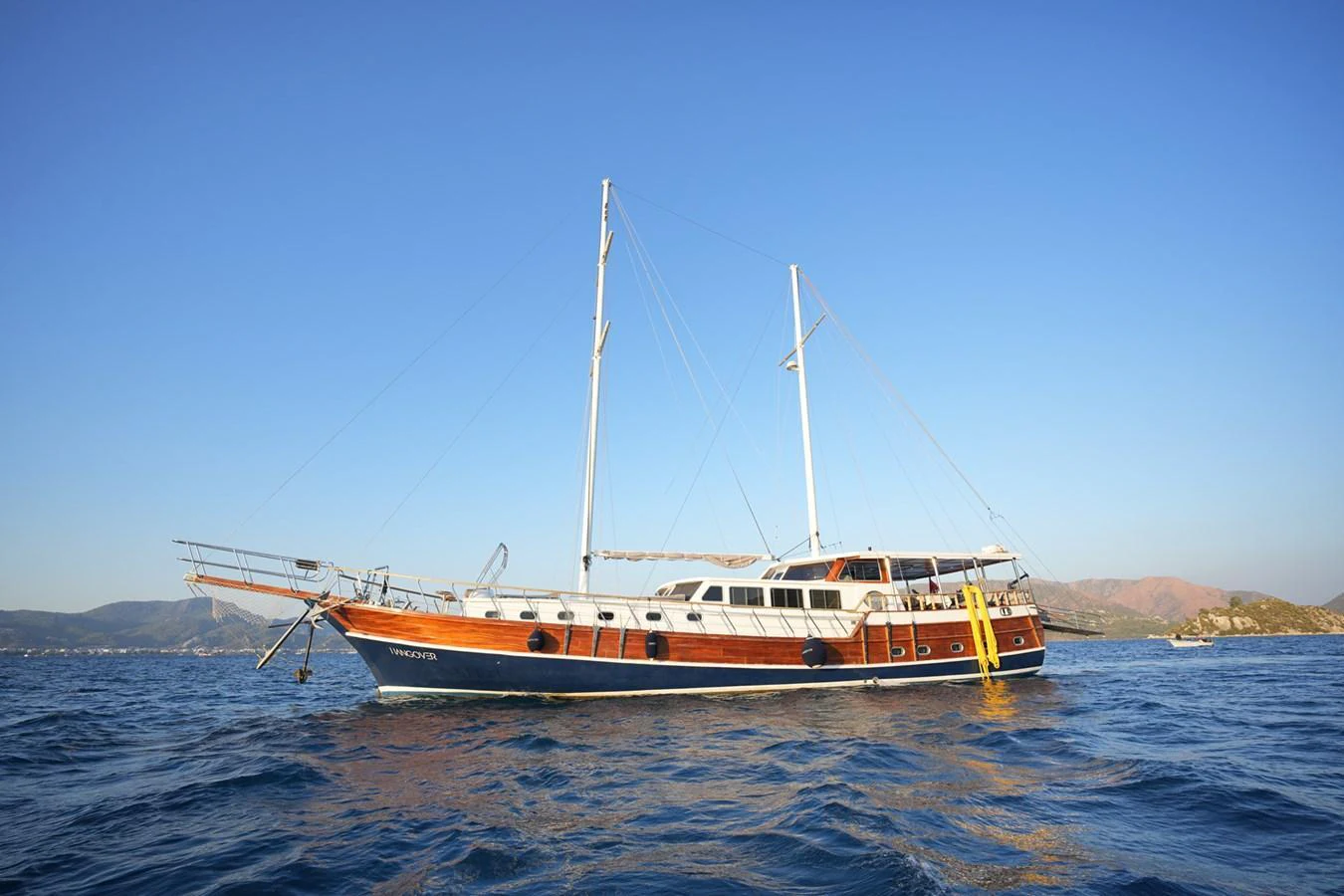 A beautiful yacht sails gracefully on the open water under a clear blue sky. aboard HANGOVER Yacht for Sale