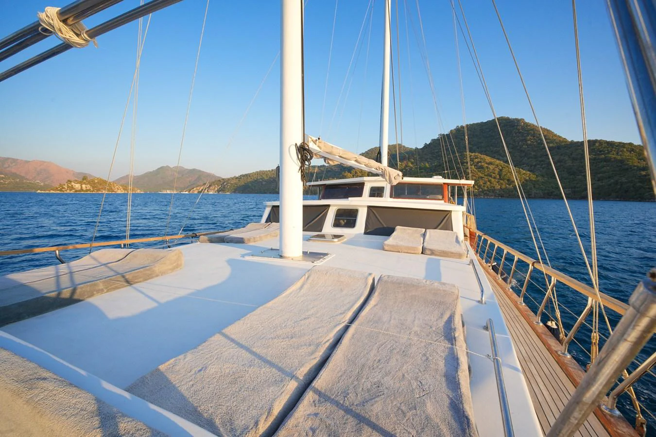 The yacht's spacious deck offers a serene view of the surrounding waters and distant hills. aboard HANGOVER Yacht for Sale