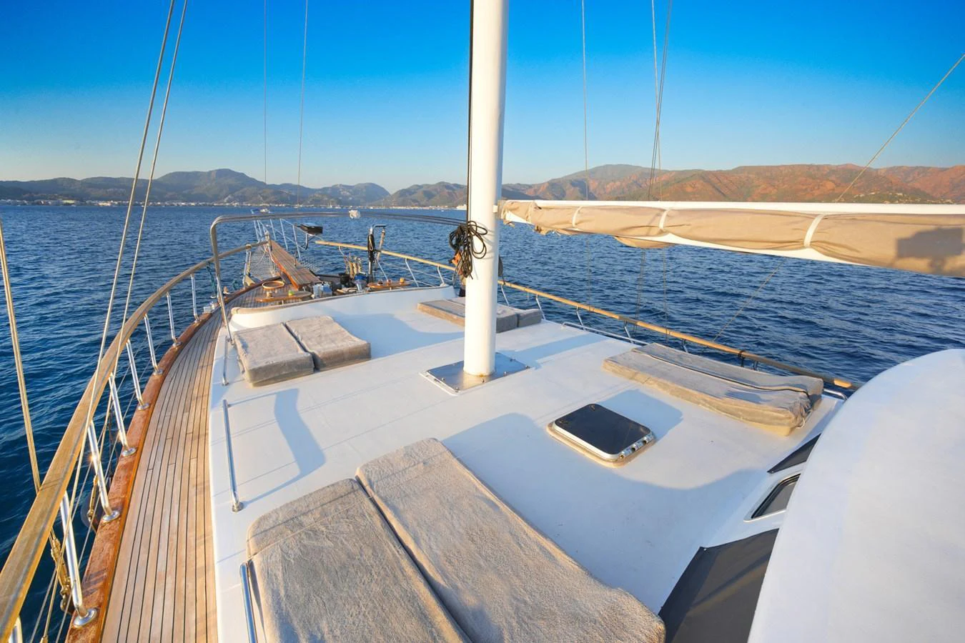 The spacious deck offers a serene setting with sun loungers and panoramic sea views. aboard HANGOVER Yacht for Sale