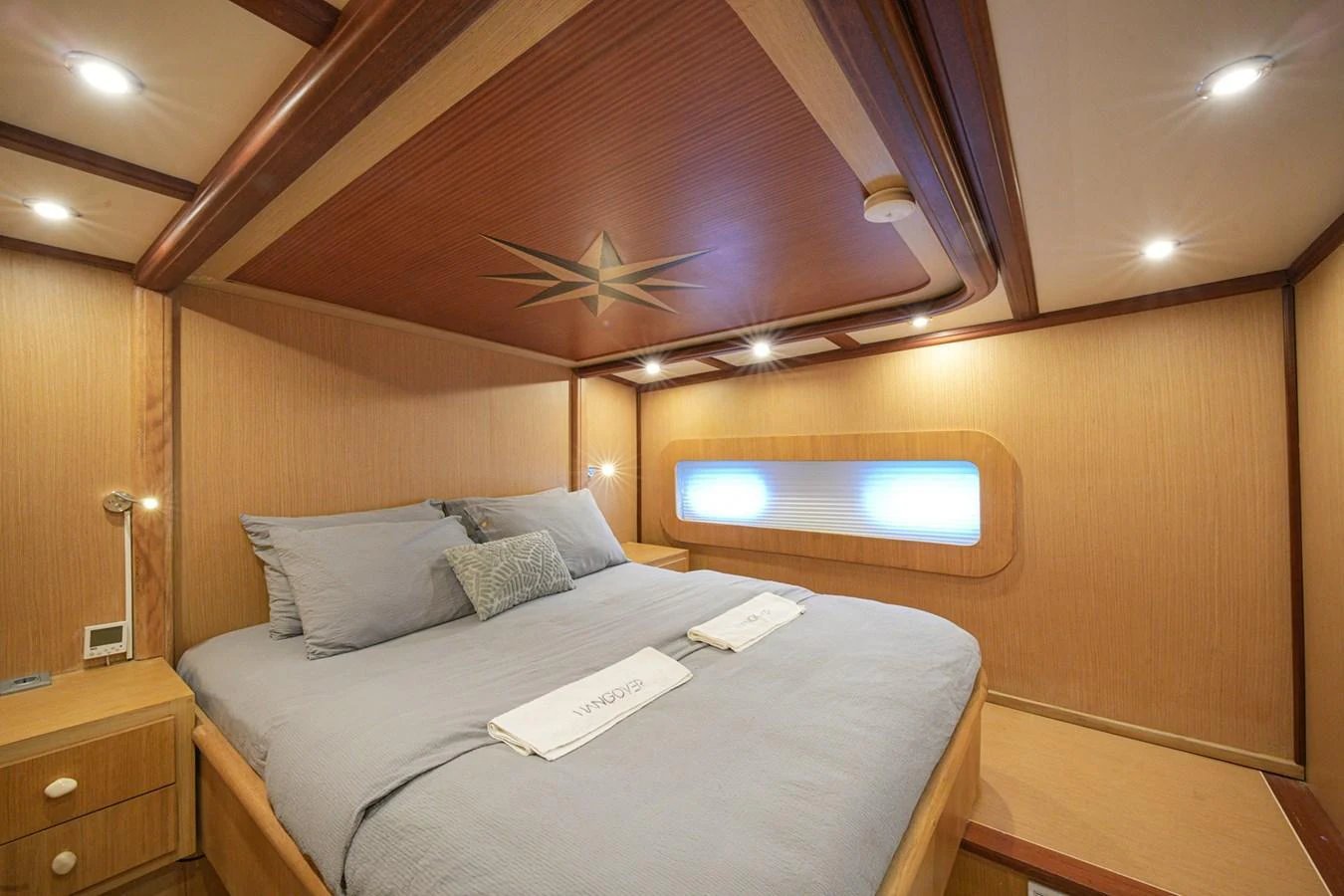 A cozy stateroom featuring a comfortable bed with soft linens and warm wood paneling. aboard HANGOVER Yacht for Sale