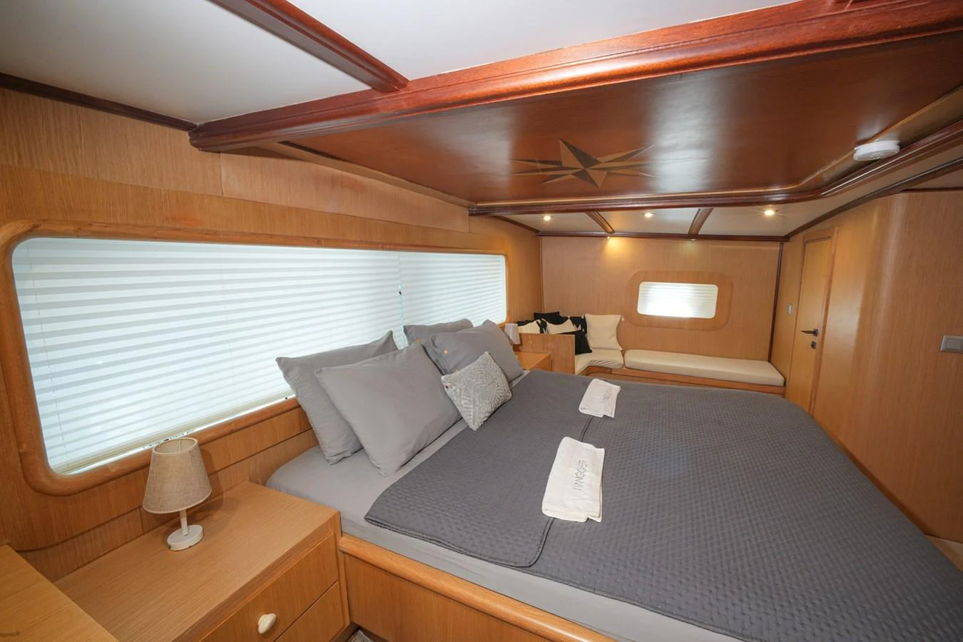 The stateroom features a spacious bed with elegant bedding and ample natural light from the large window. aboard HANGOVER Yacht for Sale