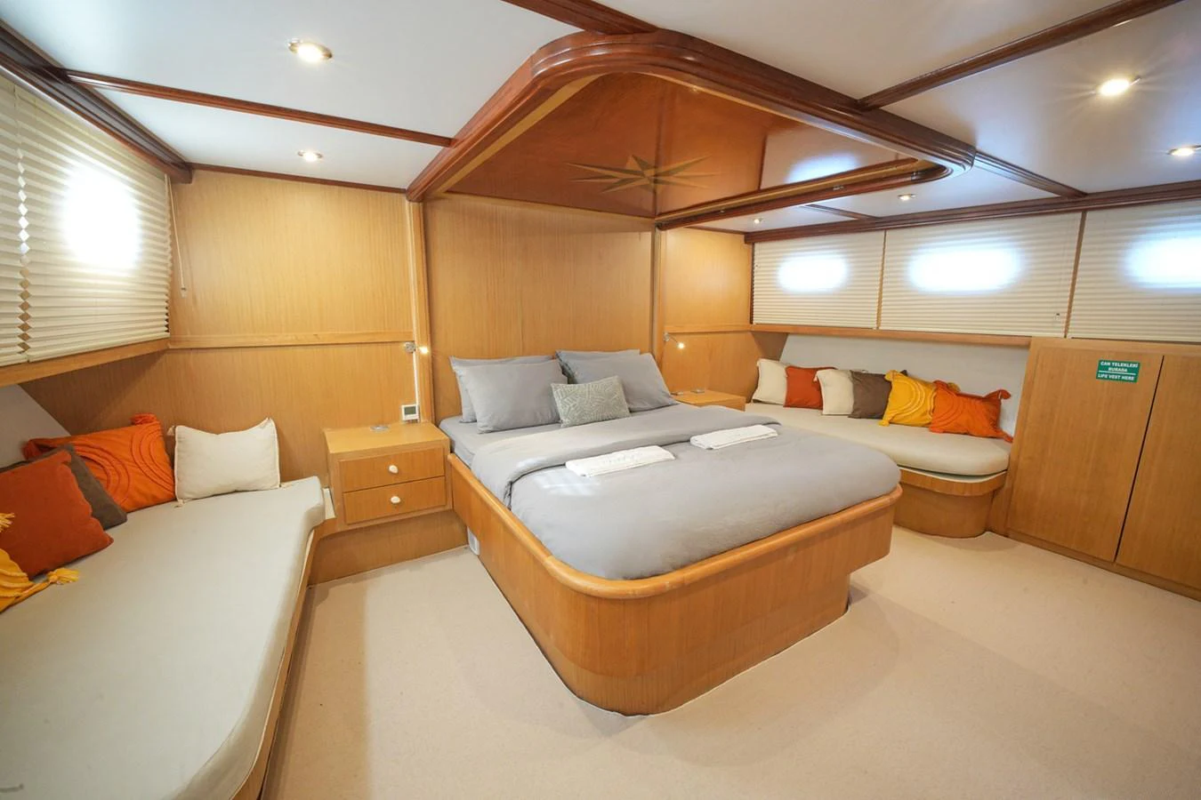 The master stateroom features a spacious bed with elegant wood finishes and ample natural light. aboard HANGOVER Yacht for Sale