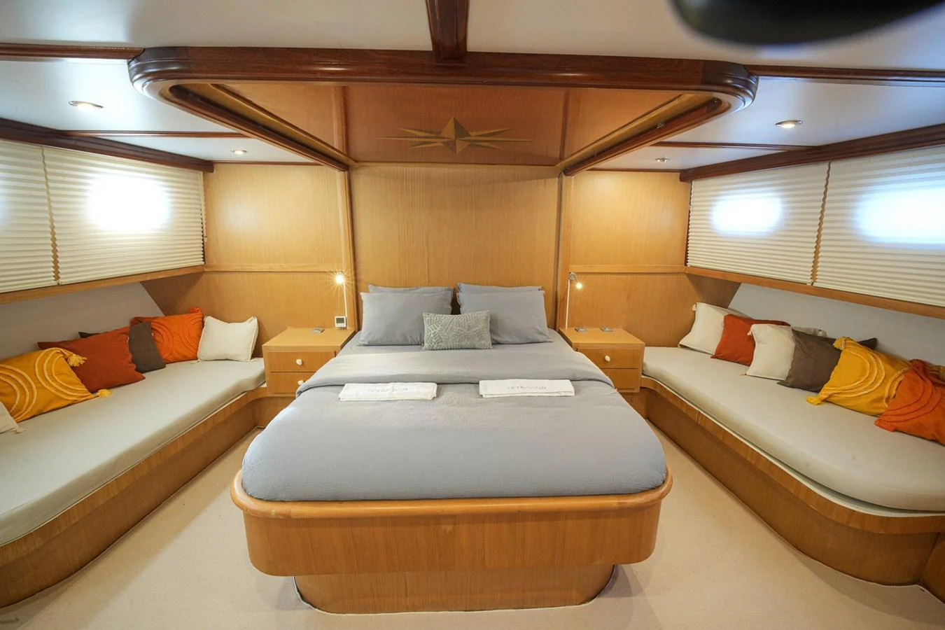 The master stateroom features a spacious bed with elegant wood finishes and ample seating. aboard HANGOVER Yacht for Sale