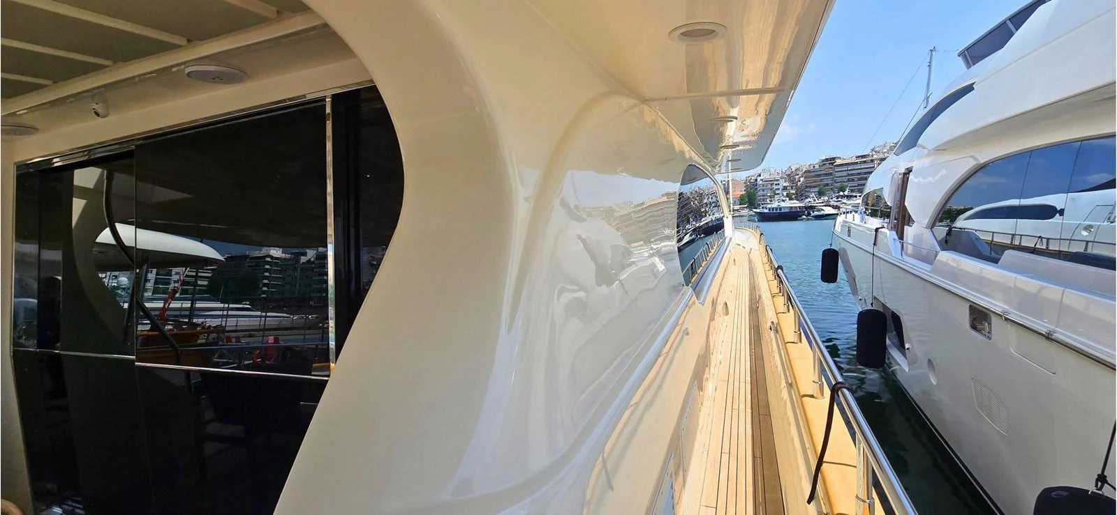 A sleek side deck of a yacht with a view of the marina and neighboring yachts. aboard BALKAN Yacht for Sale