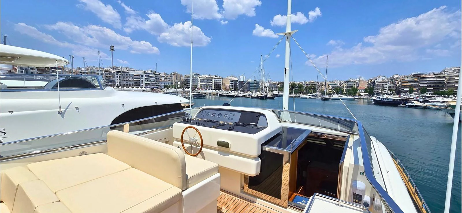 The yacht's flybridge offers a spacious and inviting area with a helm station and comfortable seating, perfect for enjoying the view of the marina. aboard BALKAN Yacht for Sale