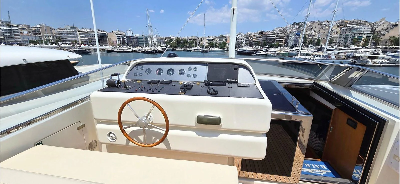 The helm station offers a commanding view with modern navigation equipment and a classic wooden steering wheel. aboard BALKAN Yacht for Sale