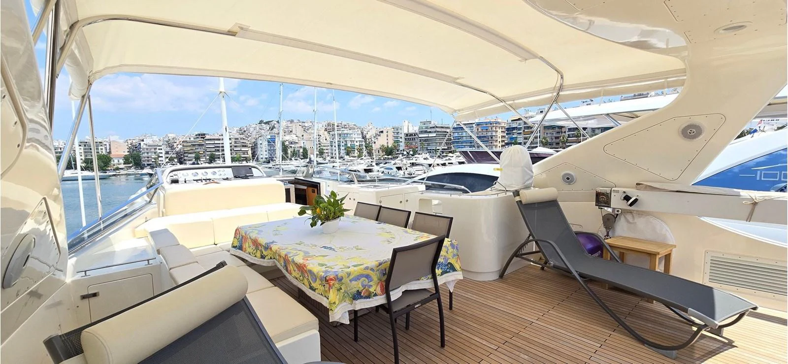 The aft deck features a spacious dining area with a table, chairs, and sun loungers under a shaded canopy. aboard BALKAN Yacht for Sale