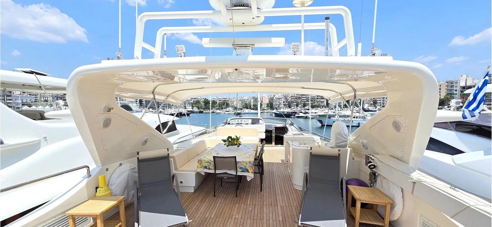 The aft deck offers a spacious and inviting area for relaxation and dining with a beautiful marina backdrop. aboard BALKAN Yacht for Sale