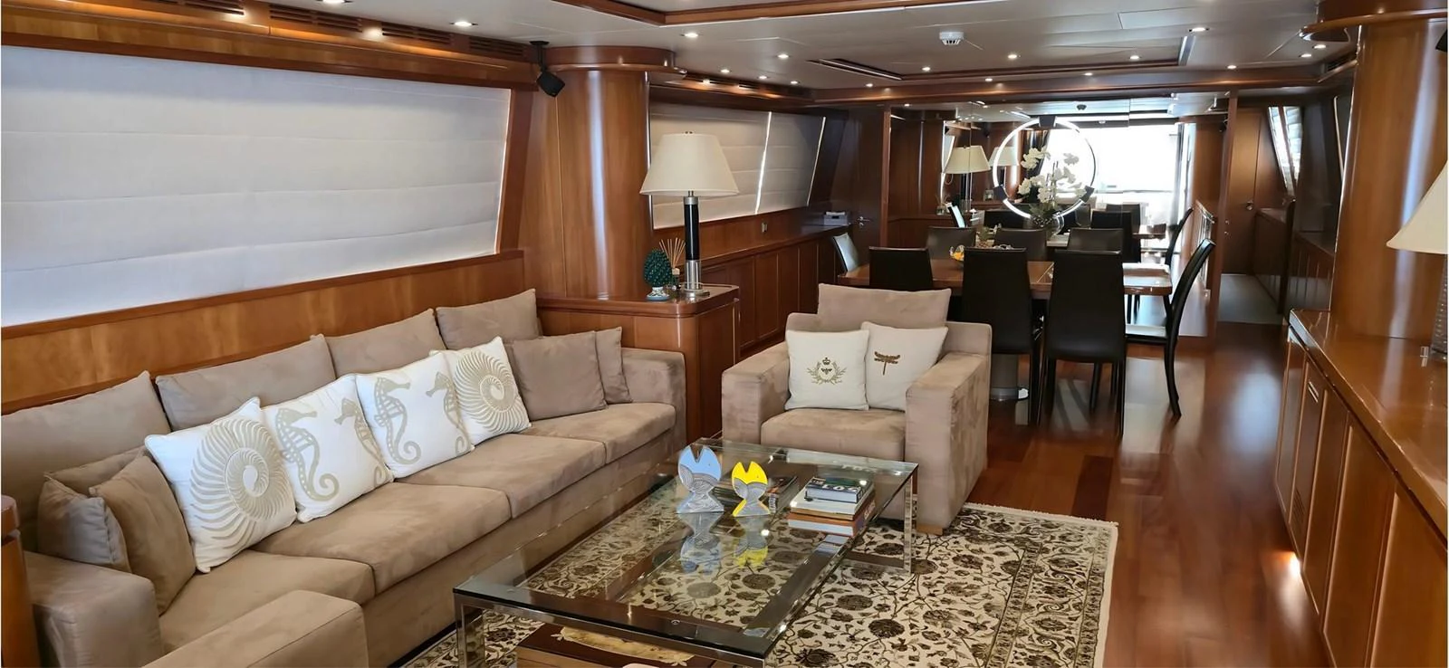 The yacht's salon features elegant wood paneling, plush seating, and a sophisticated dining area. aboard BALKAN Yacht for Sale