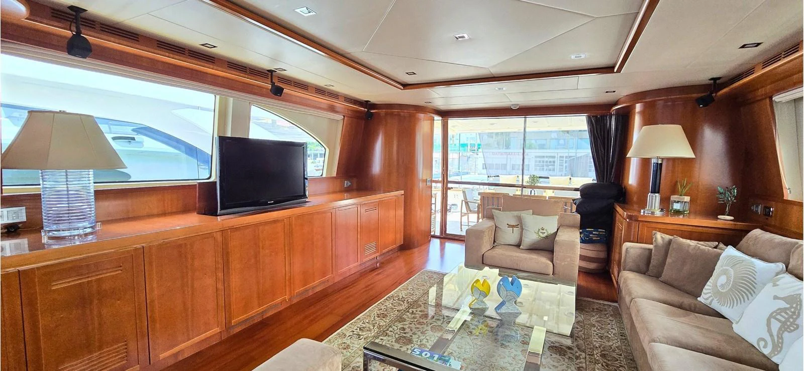 The yacht's salon features elegant wood paneling, comfortable seating, and a large flat-screen TV, creating a cozy and luxurious atmosphere. aboard BALKAN Yacht for Sale