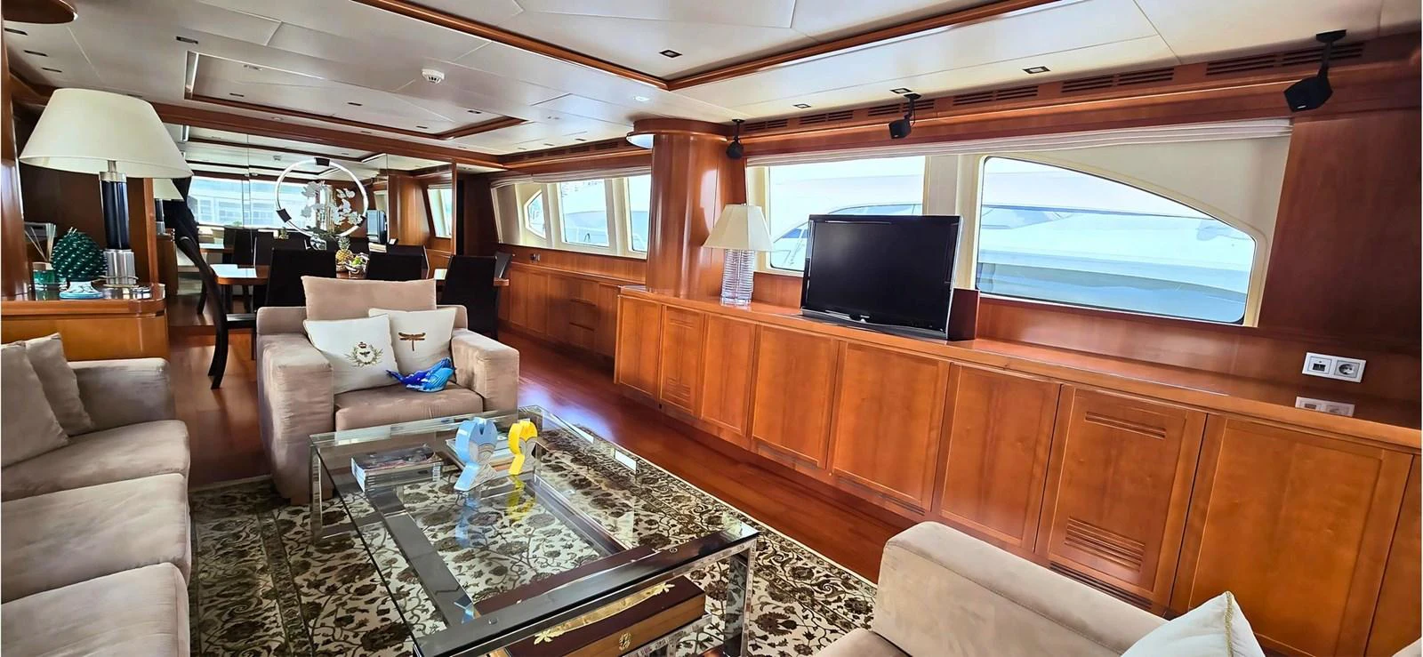 The yacht's salon features luxurious seating, a large TV, and elegant wooden finishes. aboard BALKAN Yacht for Sale