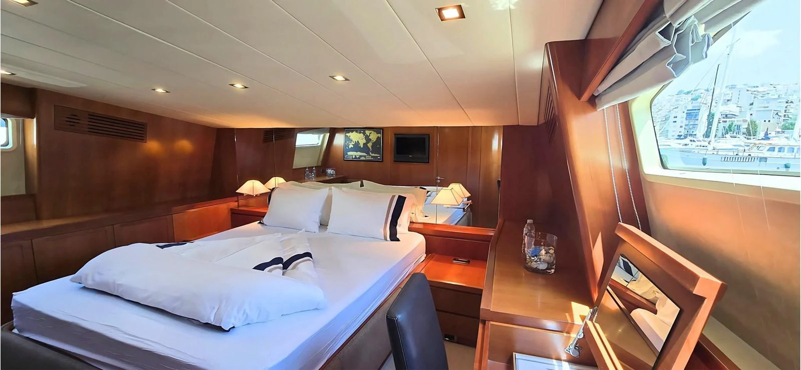 The master stateroom features a spacious bed, warm wood finishes, and ample natural light. aboard BALKAN Yacht for Sale