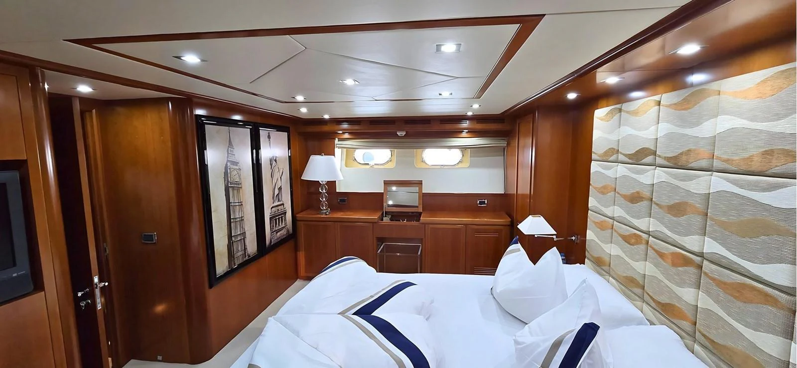 A luxurious stateroom featuring elegant wood paneling and a comfortable bed with plush pillows. aboard BALKAN Yacht for Sale