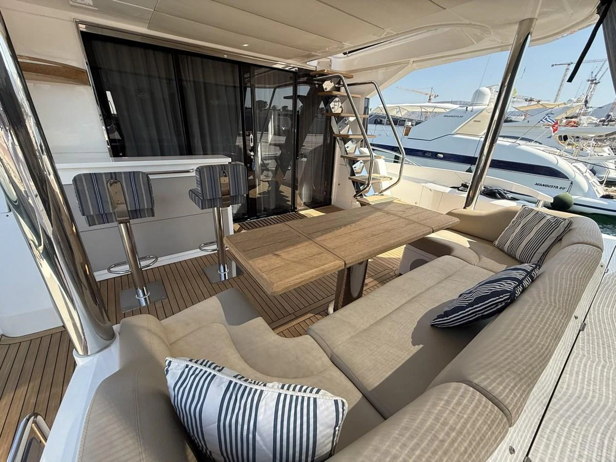 The aft deck features a cozy seating area with a wooden table and bar stools, perfect for relaxation and socializing. aboard "BISHWISH" Yacht for Sale