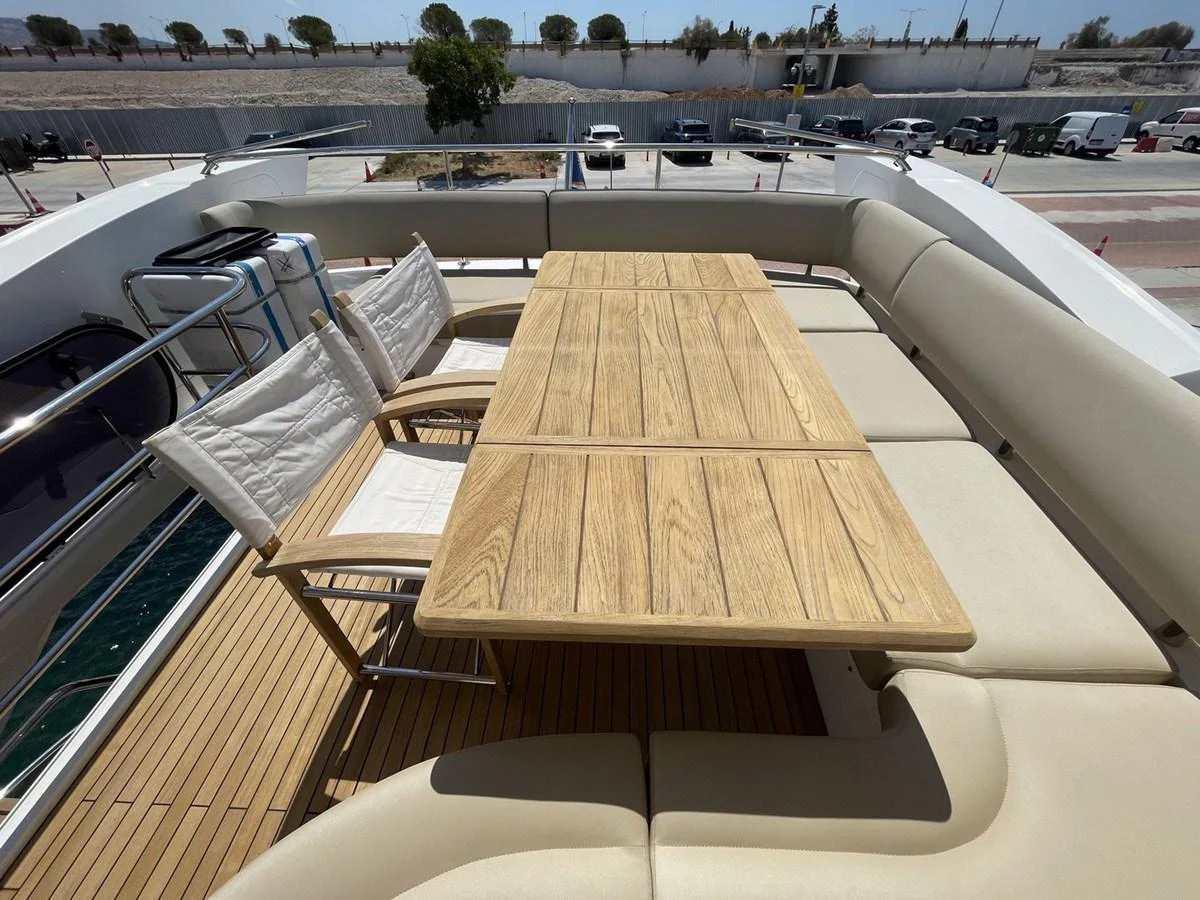 The aft deck features a spacious seating area with a wooden dining table and comfortable chairs. aboard "BISHWISH" Yacht for Sale